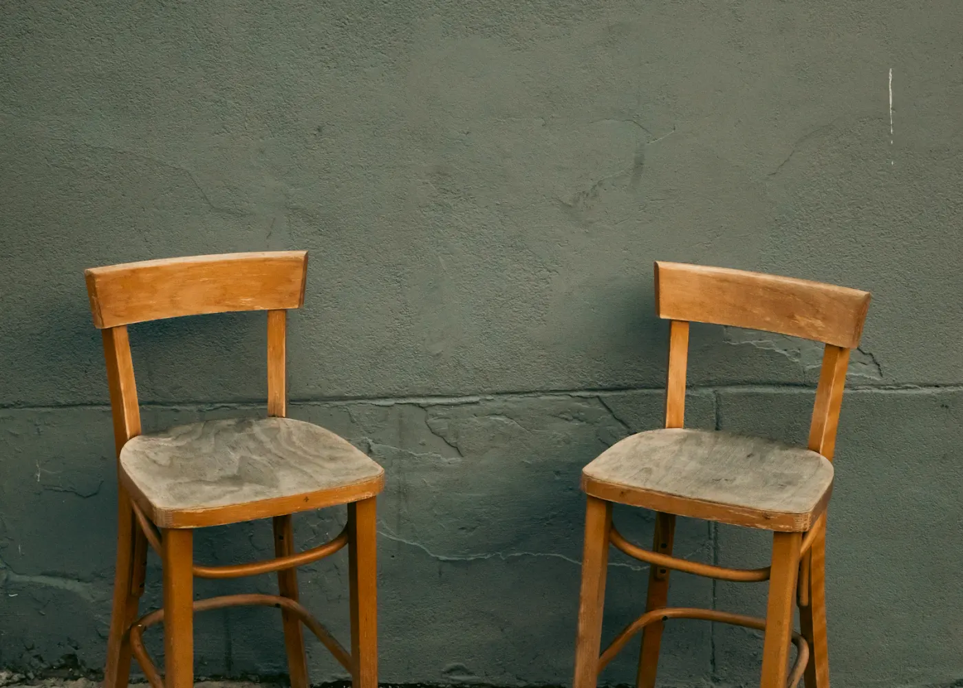Two empty chairs arranged near a quiet wall, suggesting a conversation that may resume.